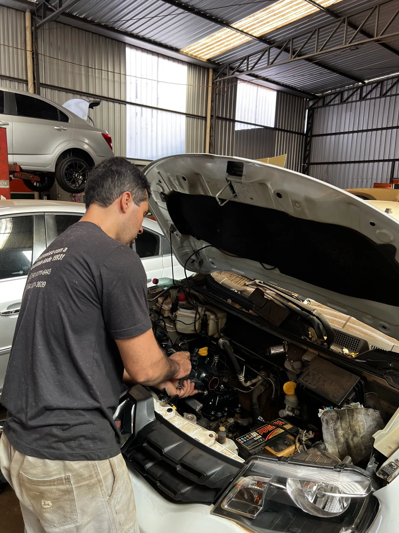 Profissional da Nova Era Auto Motors realizando manutenção em um veículo